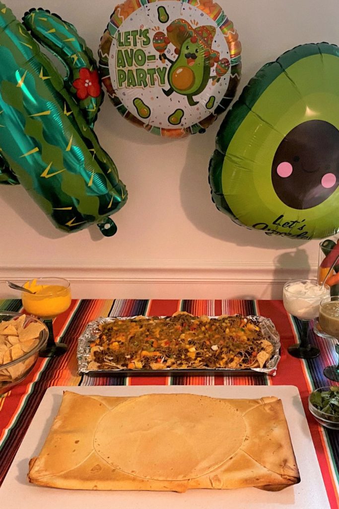 Crunch Wrap Supreme and Nachos served on a Cinco de Mayo themed table