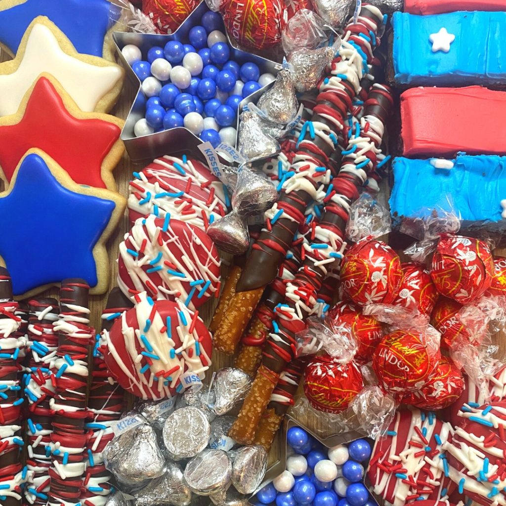 Close up image of a Patriotic Charcuterie Board with red, white, and blue chocolates, cookies, and brownies