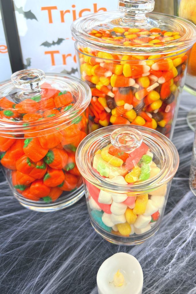 Halloween candy corn and candy pumpkins in plastic jars